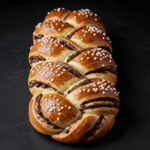 Freshly baked braided chocolate chip brioche loaf with golden-brown crust.