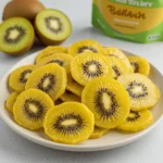 Golden kiwi chips arranged on a plate, showcasing the crispy texture and vibrant yellow color.