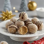 Plate of Moose Farts no-bake treats, rolled into bite-sized balls, coated with shredded coconut and drizzled with chocolate.